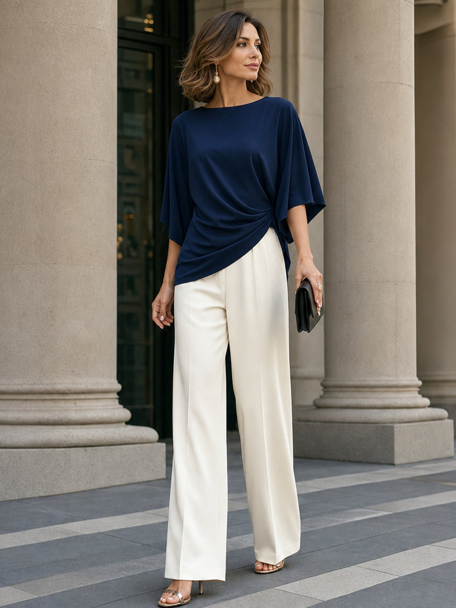 A business woman wearing a navy wrap blouse with cream wide-leg pants